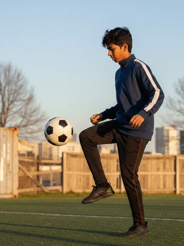 Portrait of a young man with curly hair wearing a yellow hoodie and backpack