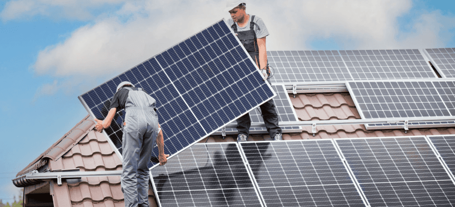 Zwei Solarteure die eine Photovoltaik Anlage auf einem Dach installieren