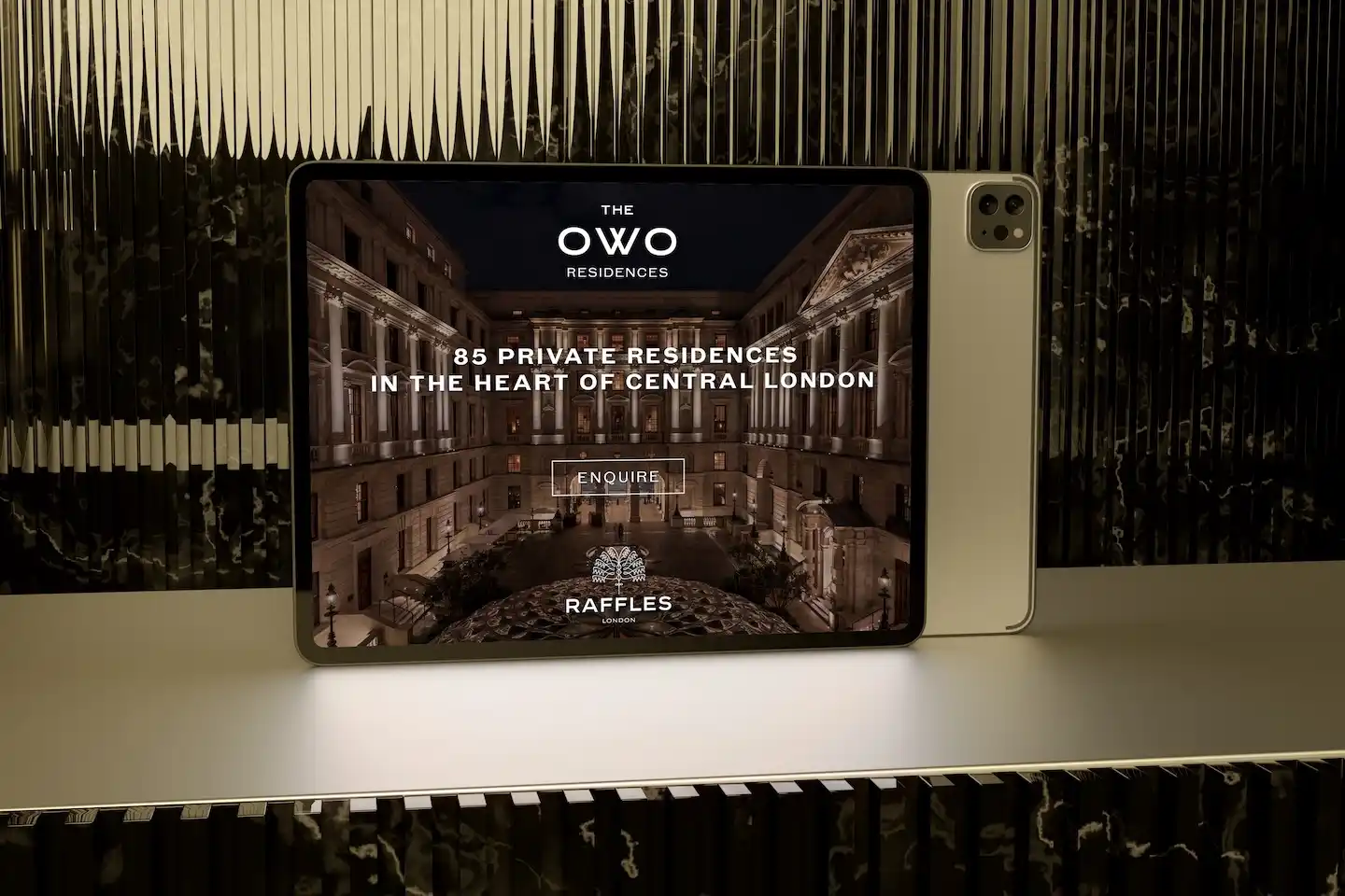 Tablet displaying The OWO digital enquiry page at night showcasing the illuminated courtyard of the development.