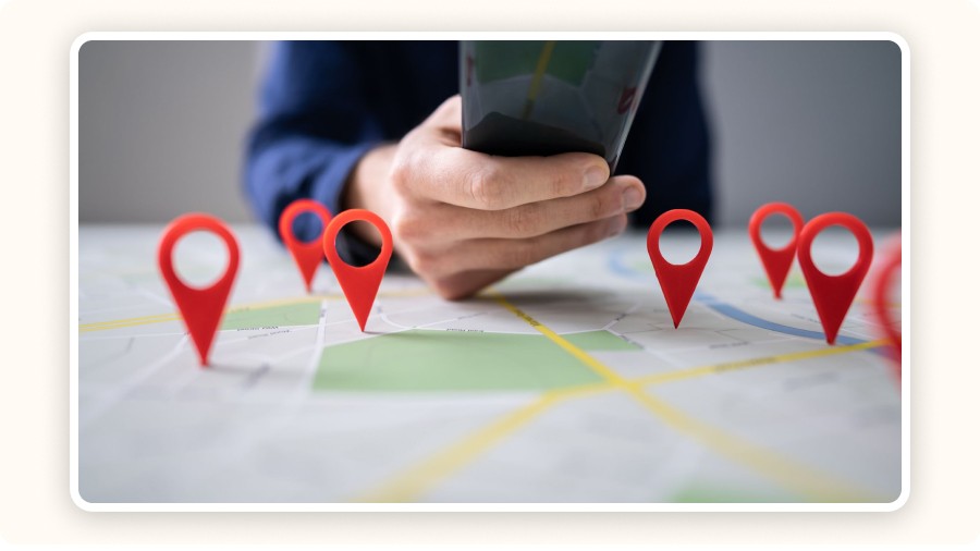 Person using smartphone over map with multiple location pins