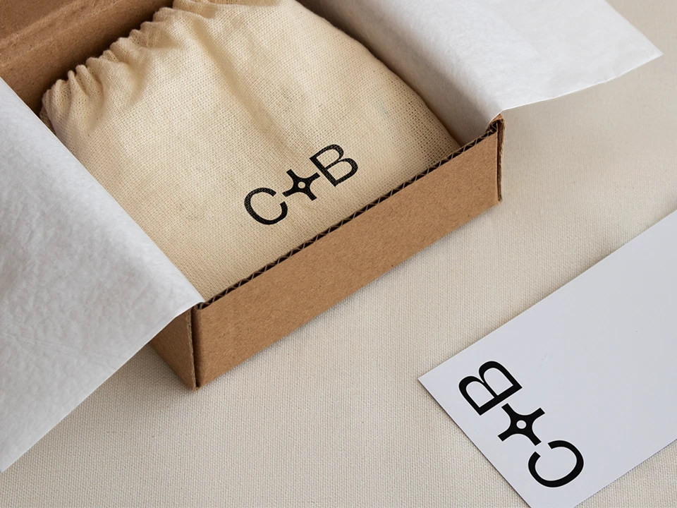 A photograph of a box with a little bag and a sticker