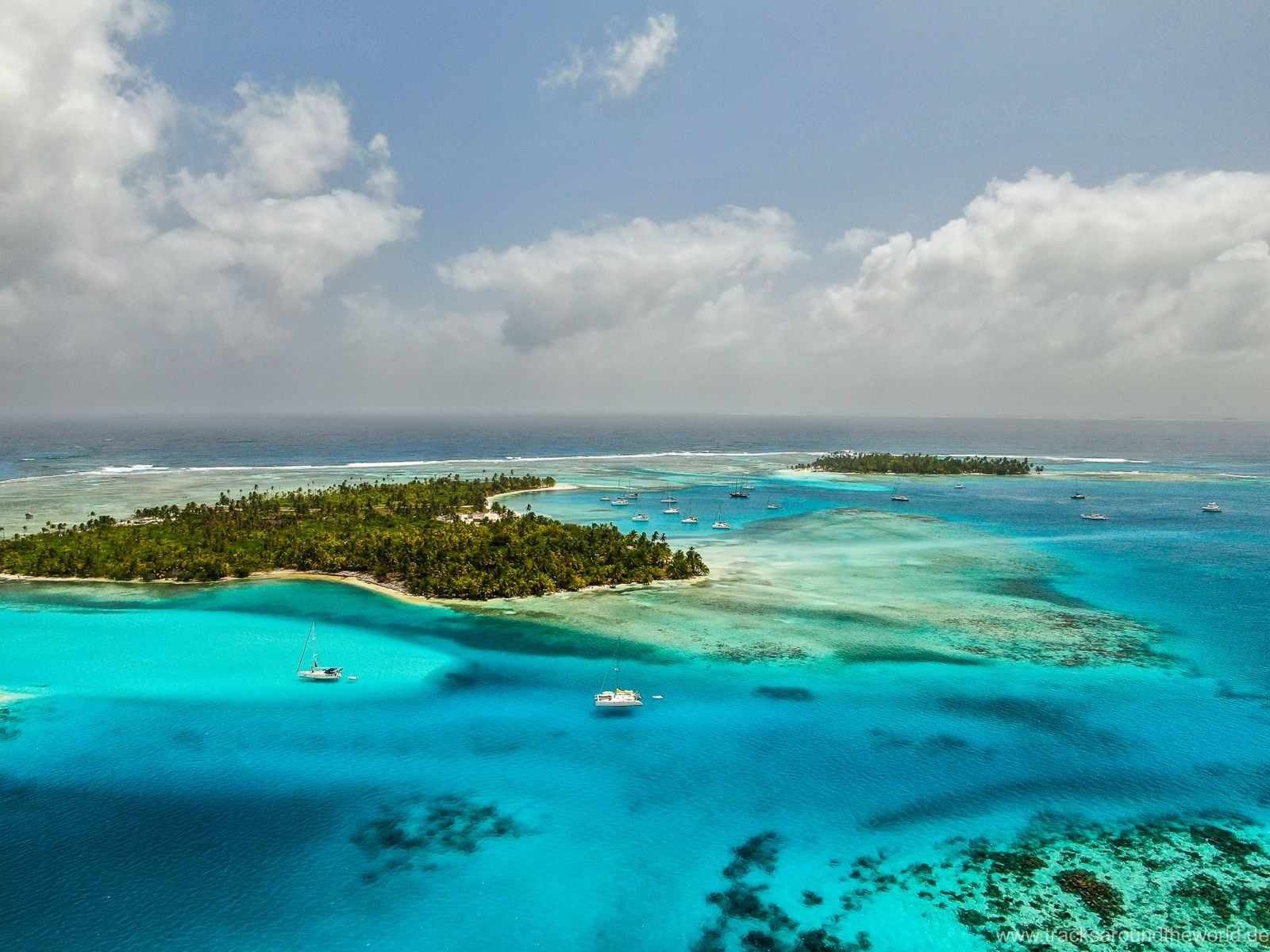 A stunning, aerial shot of the 365 islands taken from a plane, with the Nomad Sailors Catamaran visible below