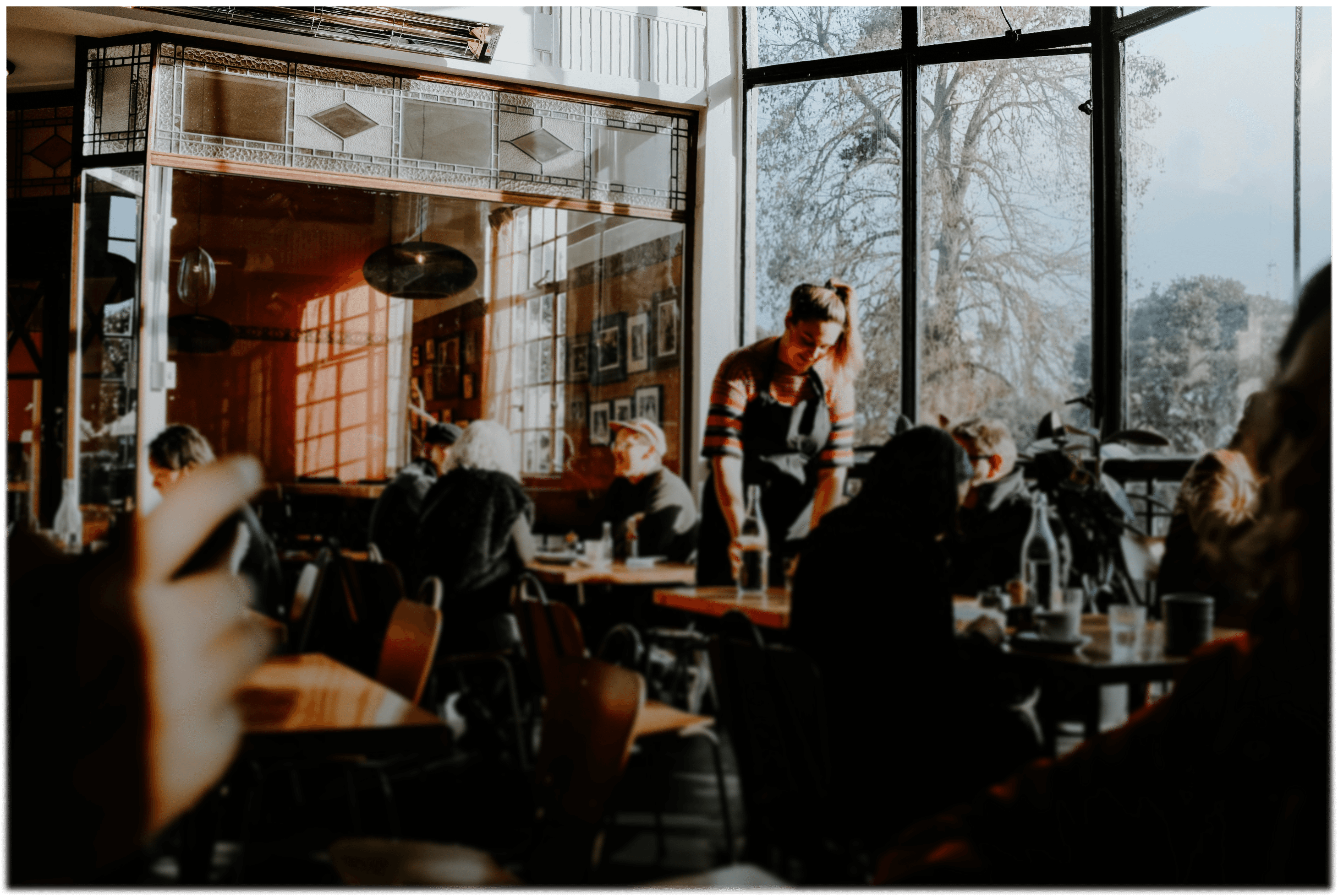 A waiter takes an order from customers at a cafe.