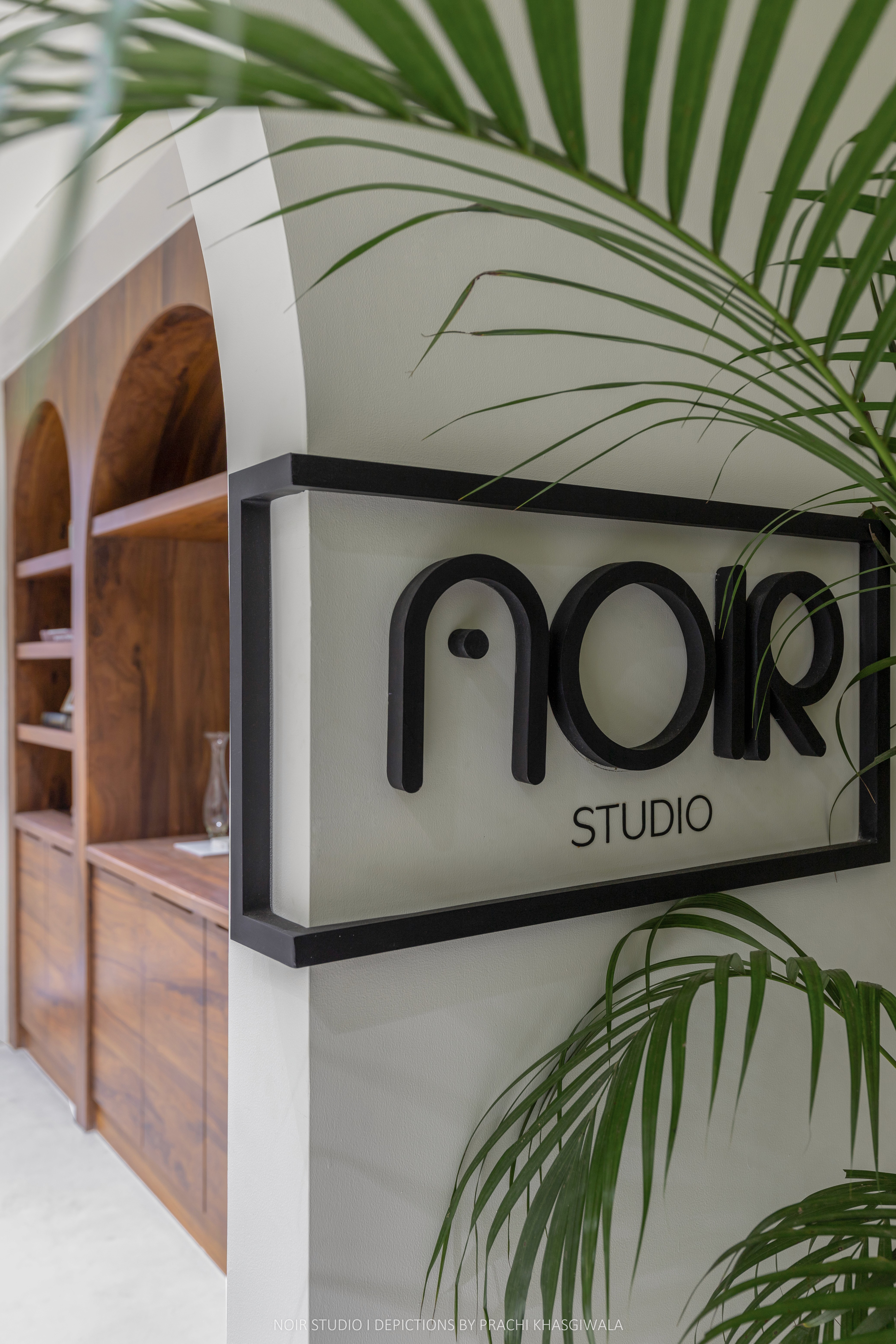 Black and white image of people working at a table with laptops, showing hands gesturing during discussion of digital content displayed on screens, with fabrica® logo in the corner.