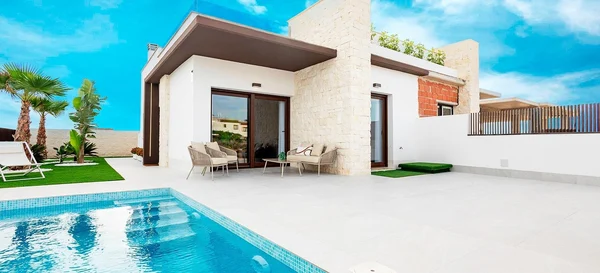 Moderne villa met privézwembad en terras onder een blauwe lucht