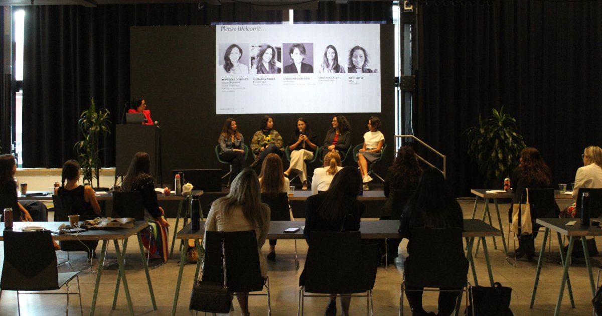 Women sitting at tables looking at a presentation