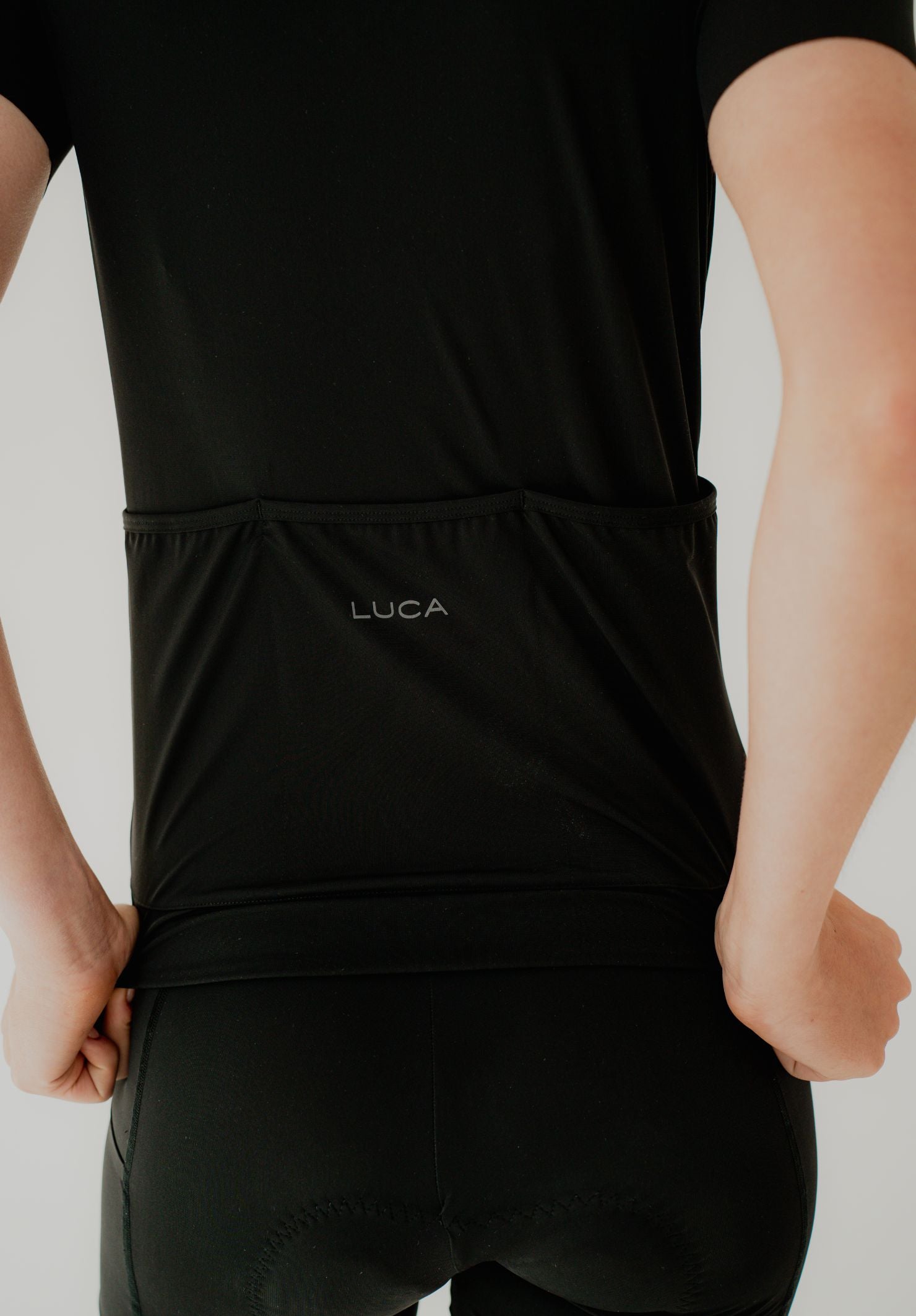 Person-wearing--Solstice Jersey - Black-clothing-with-LUCA-printed-on-the-waistband