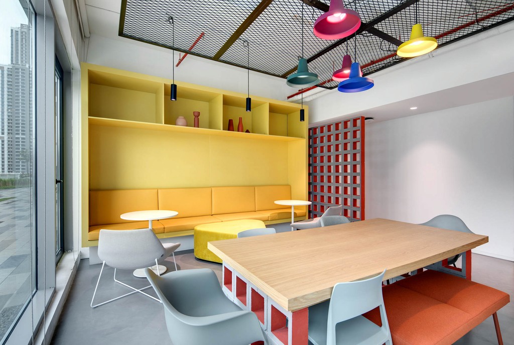 A modern conference room with blue seating and a circular light, situated in The Binary by OMNIYAT.