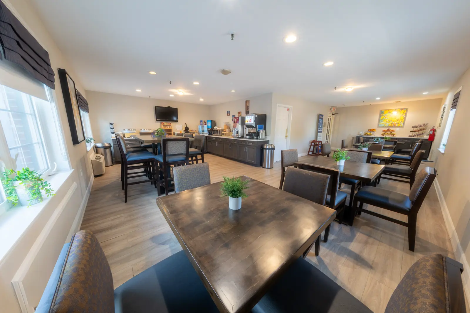 Dining area with tables and chairs, and a counter with food and beverage options.