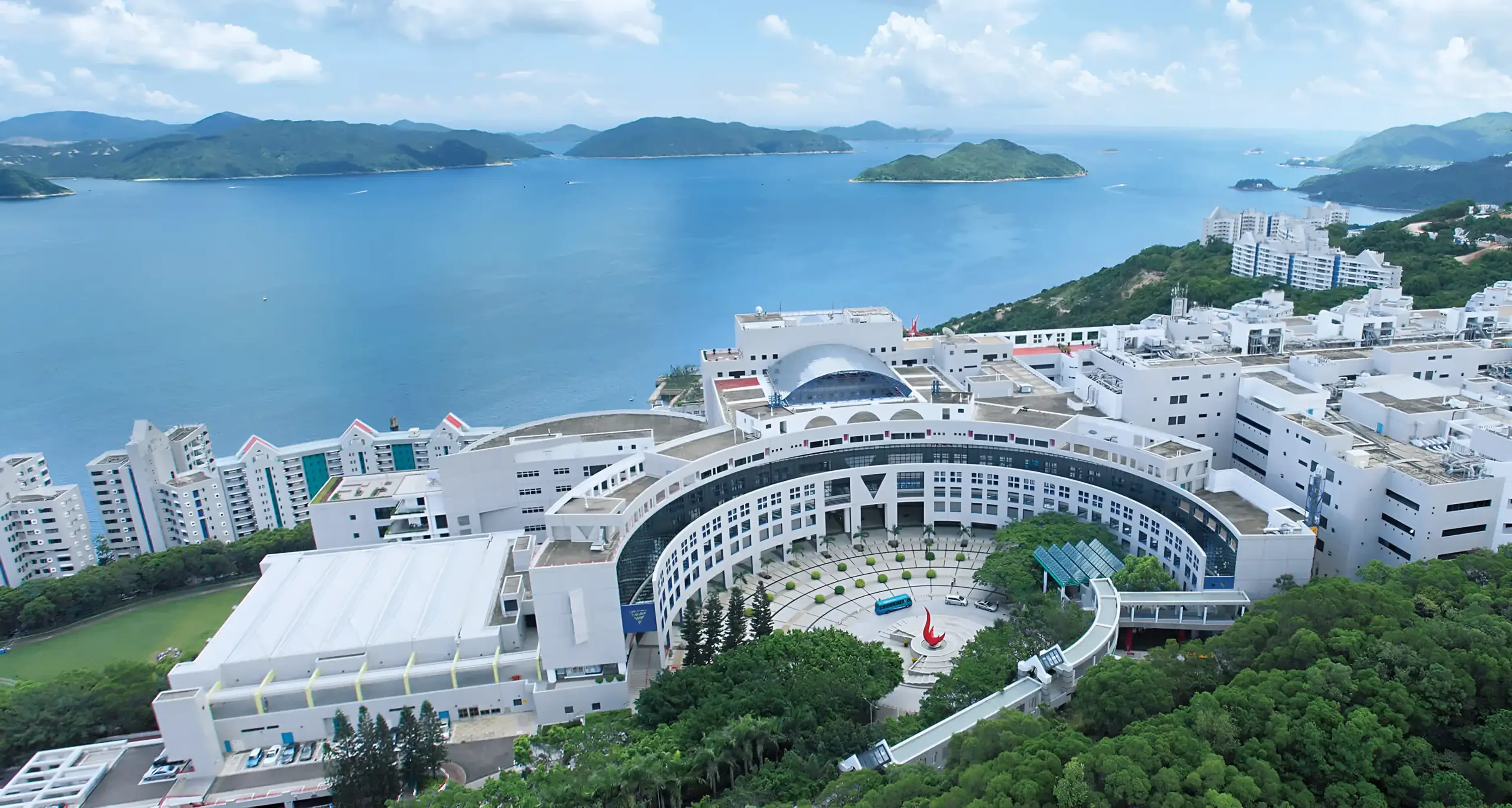 HKUST Clear Water Bay campus aerial view – modern white buildings overlooking sea and hills, highlighting natural and cultural environment for HKUSTours campaign by Teatime Studio.
