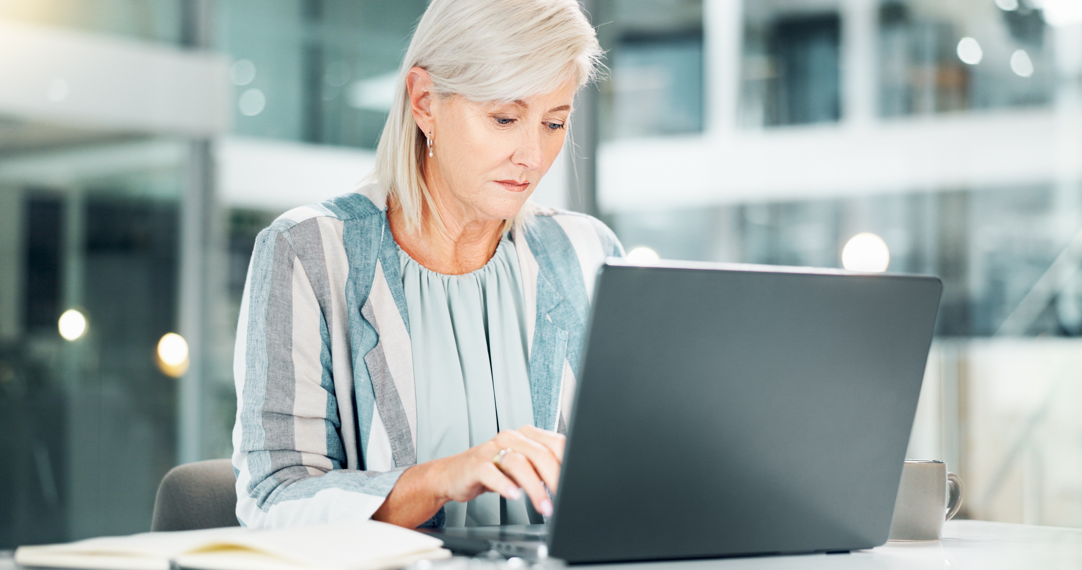 Senior professional working intently on a laptop in a modern office setting, representing structured risk analysis, foresight, and informed decision-making under uncertainty.