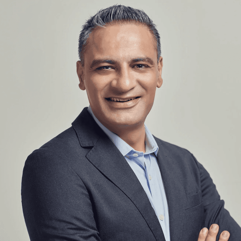Portrait of a smiling team member in a dark suit and light blue shirt