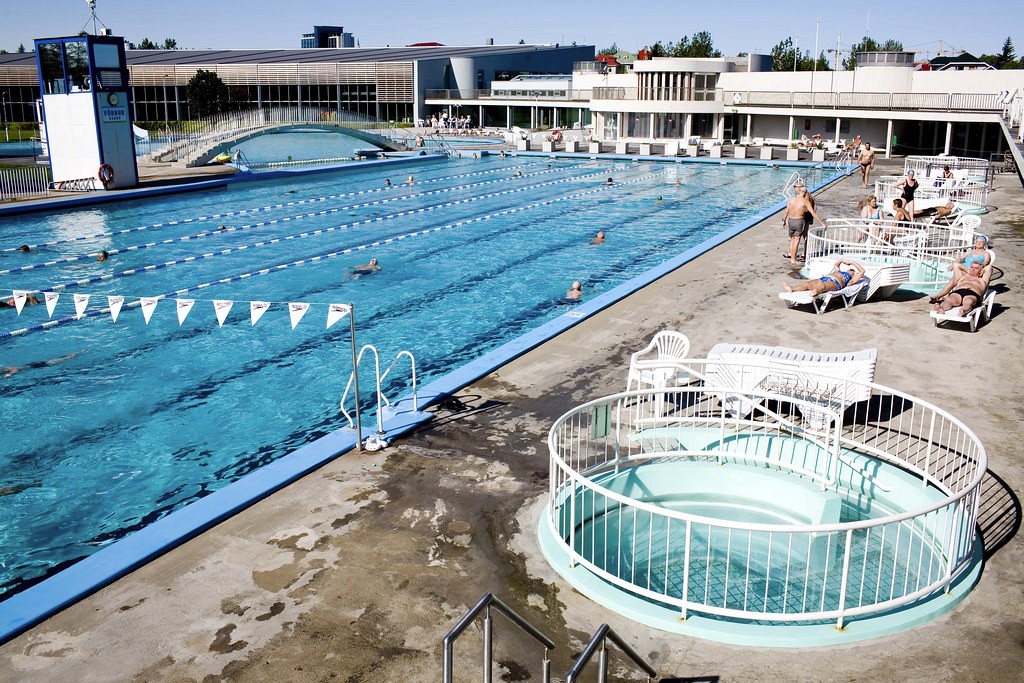 Steam rising from the surface of an outdoor geothermal pool in Reykjavík in cool late afternoon light