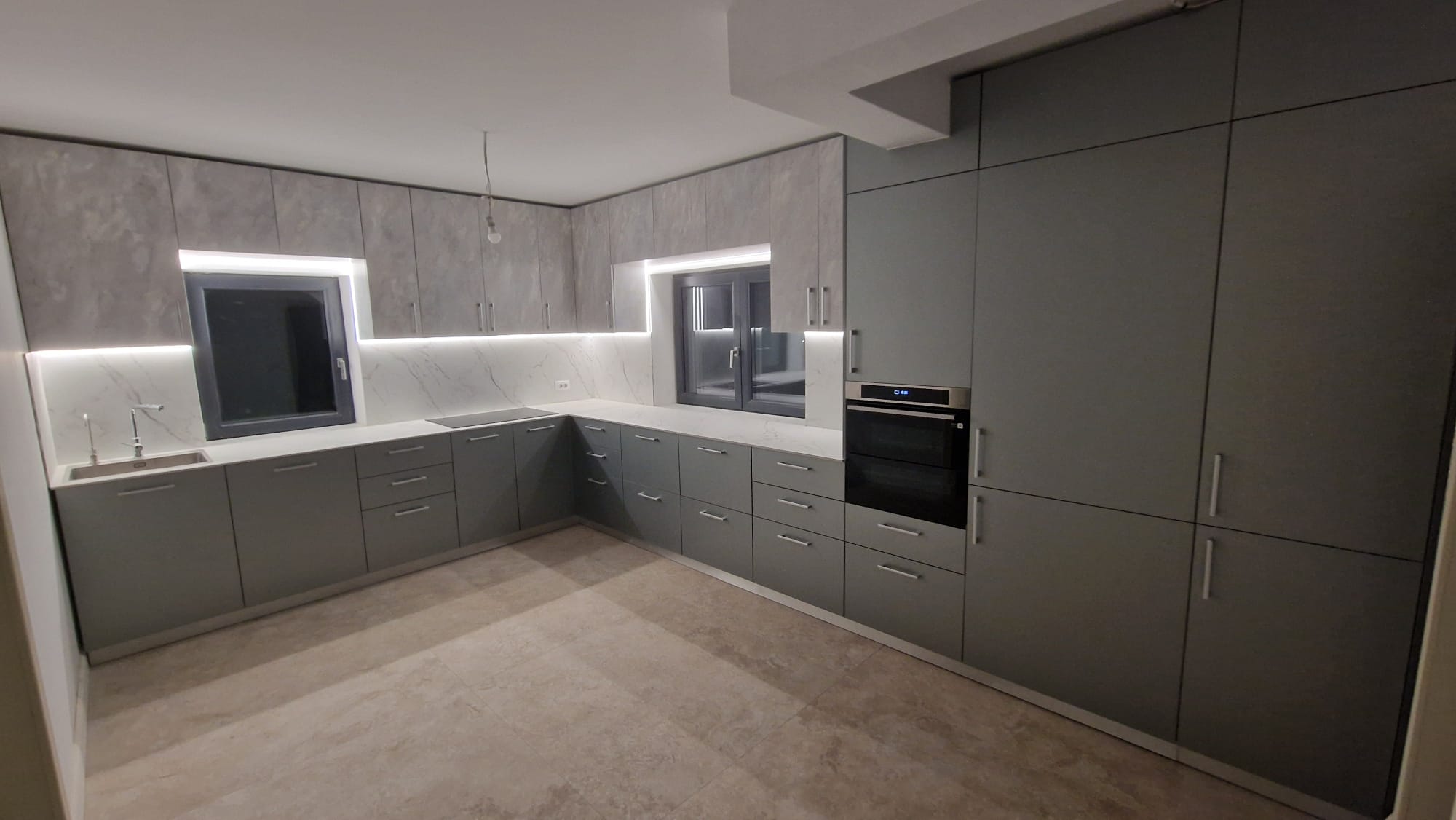 Variantă panoramică a nișei de hol: riflaj lemn, dulapuri inferioare bej și ușă laterală, spațiu luminos.