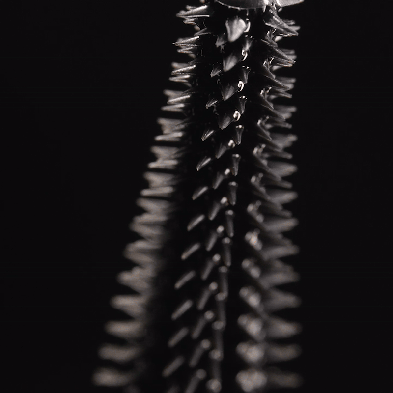 A close-up of a person wearing green-tinted glasses, with a serious expression and smooth skin.