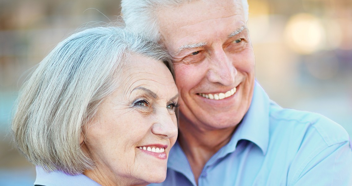 Smiling elderly couple showing healthy teeth