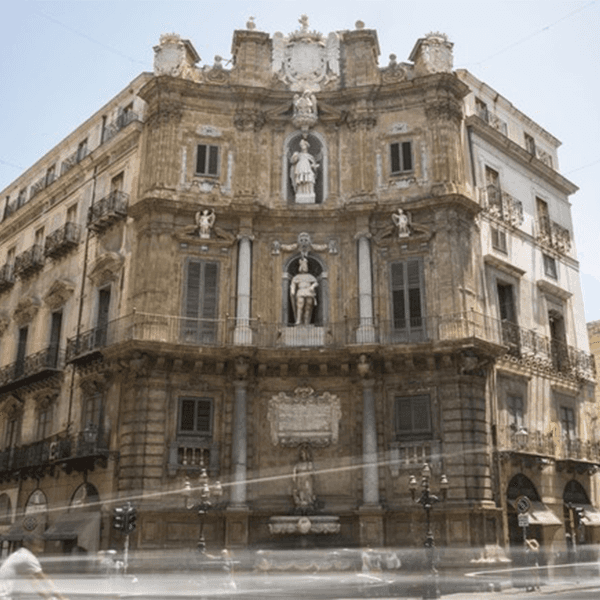 Fachada barroca de esquina com estátuas em nichos, no centro histórico de Palermo, Itália