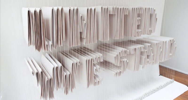An art work made from hanged paper napkins that spells: United We Stand.