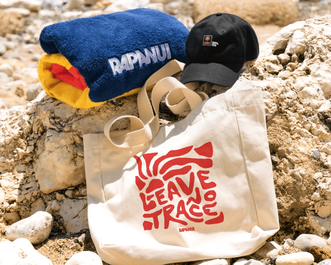 Muscular woman in black athletic wear performing a one-arm handstand against a dark neutral studio background.