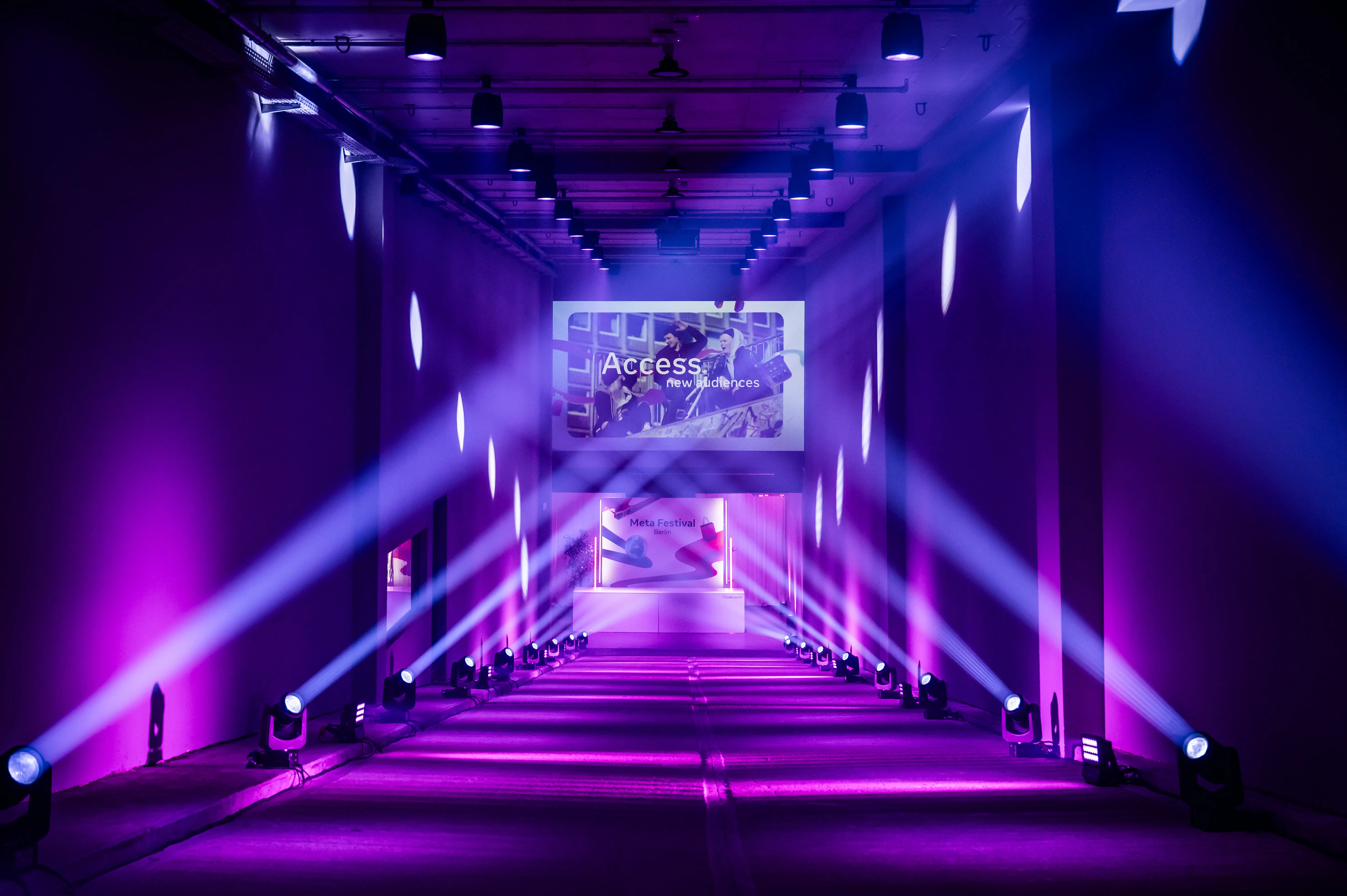 Symmetrical light tunnel in violet with Access screen and rows of beam spotlights.
