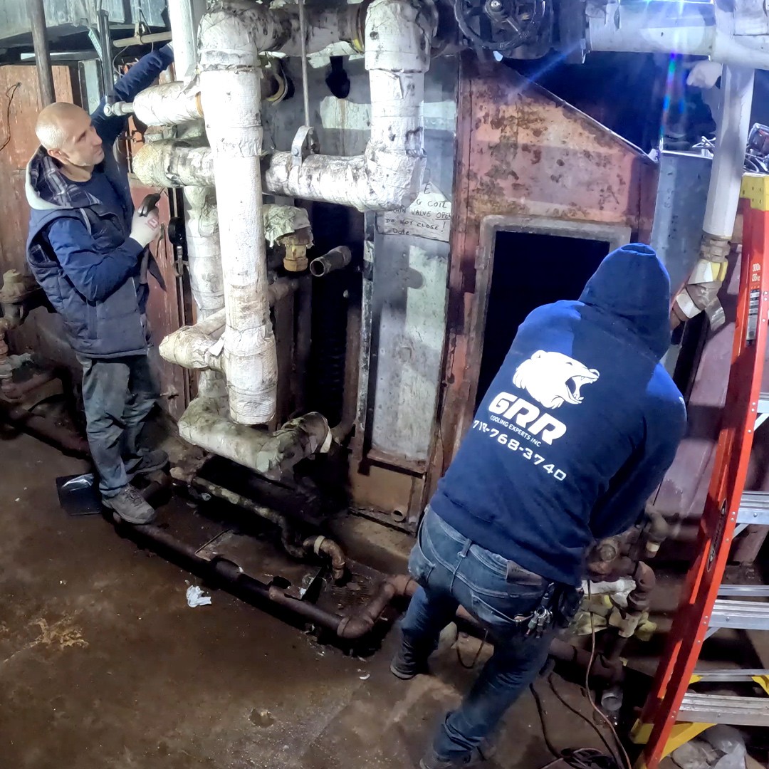GRR Cooling Experts technician working on chilled-water piping inside a hospital mechanical room.