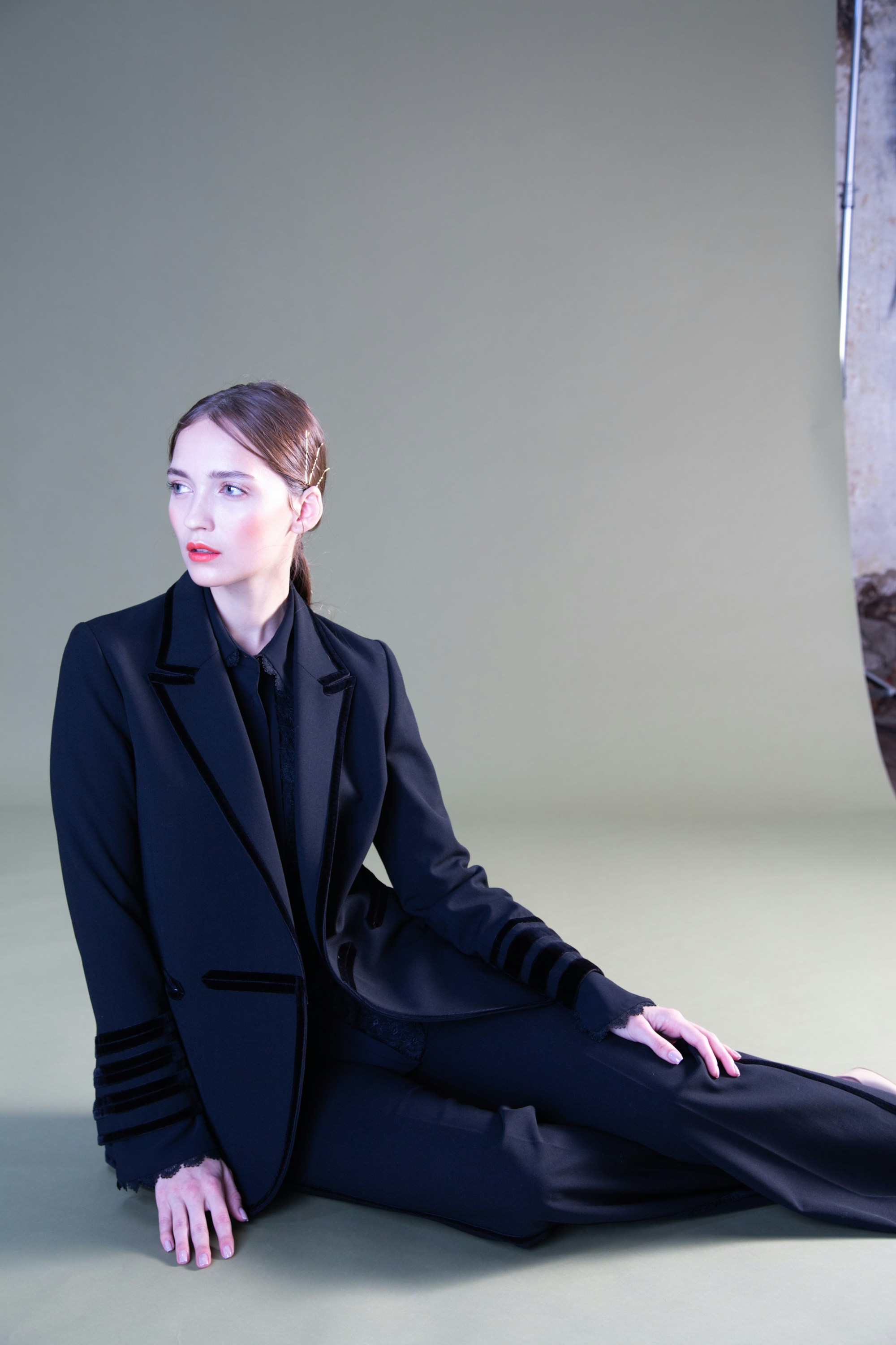 Model in a black suit sitting on the floor