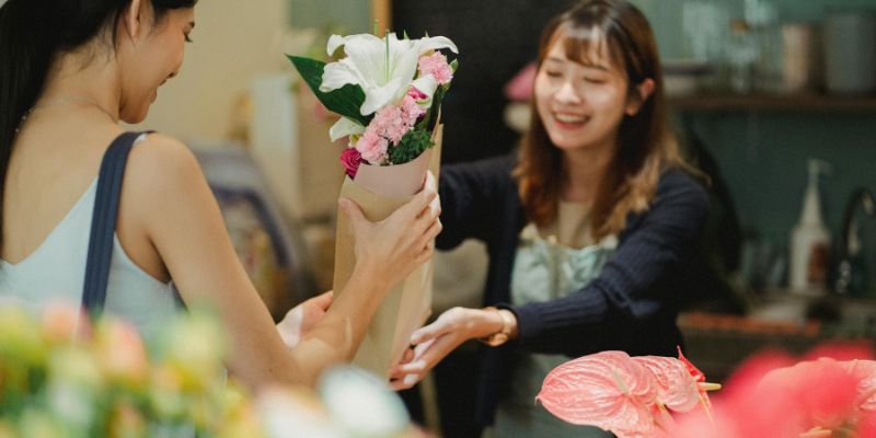 A Malaysian flower shop owner talking with a customer