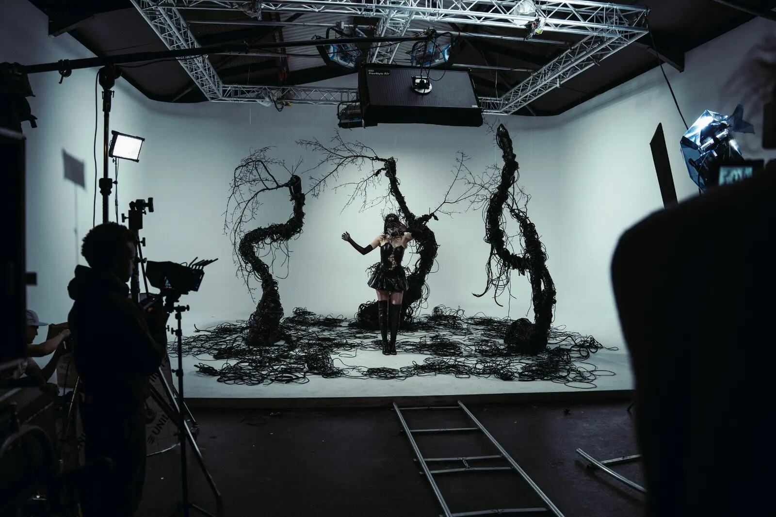 Wide behind-the-scenes view of lighting, camera tracks and set design in a studio
