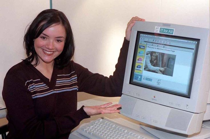 Woman next to an old all in one computer with a screen reading IT for All