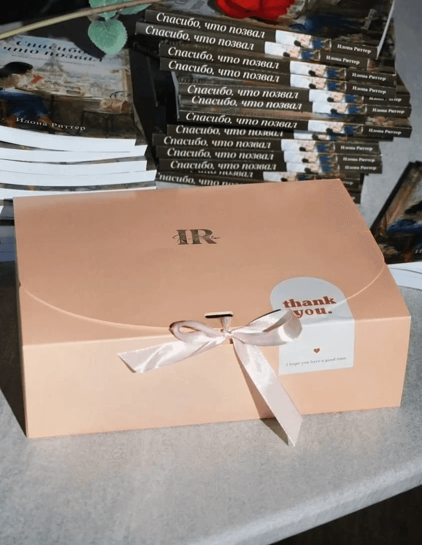 a green box with a tag tied to it sitting on a table next to a