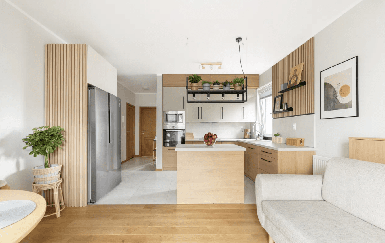 mieszkanie, jasny salon z kuchnią, w głębi widać korytarz