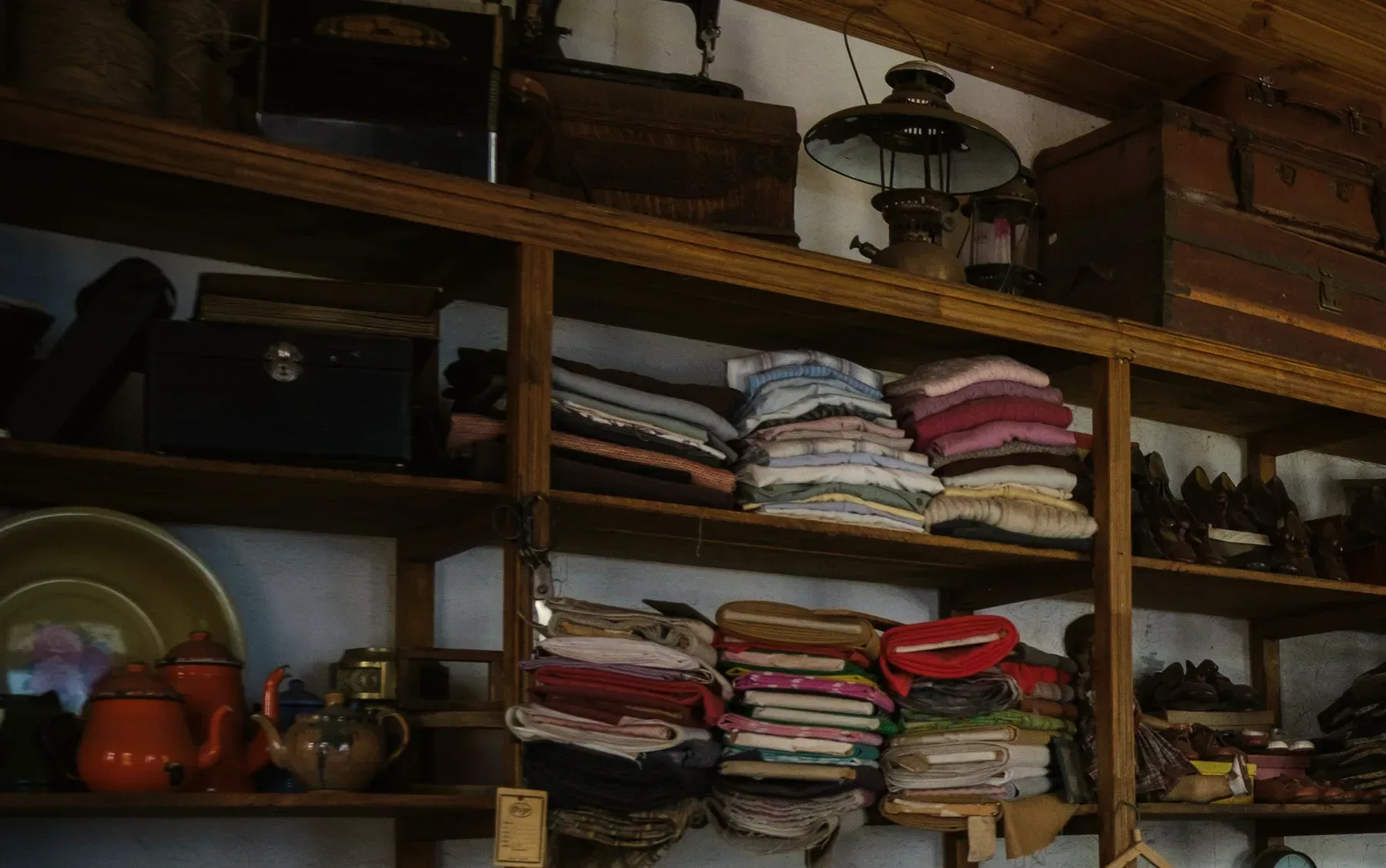 Wooden shelves of folded blankets and enamel pots