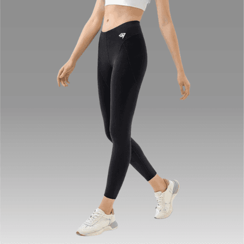 Person wearing black leggings with a logo on a gray background