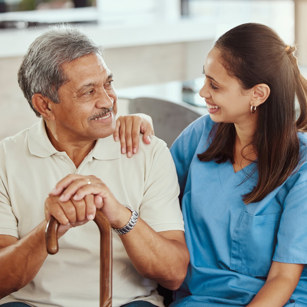 Doctor sitting on couch with patient smiling.