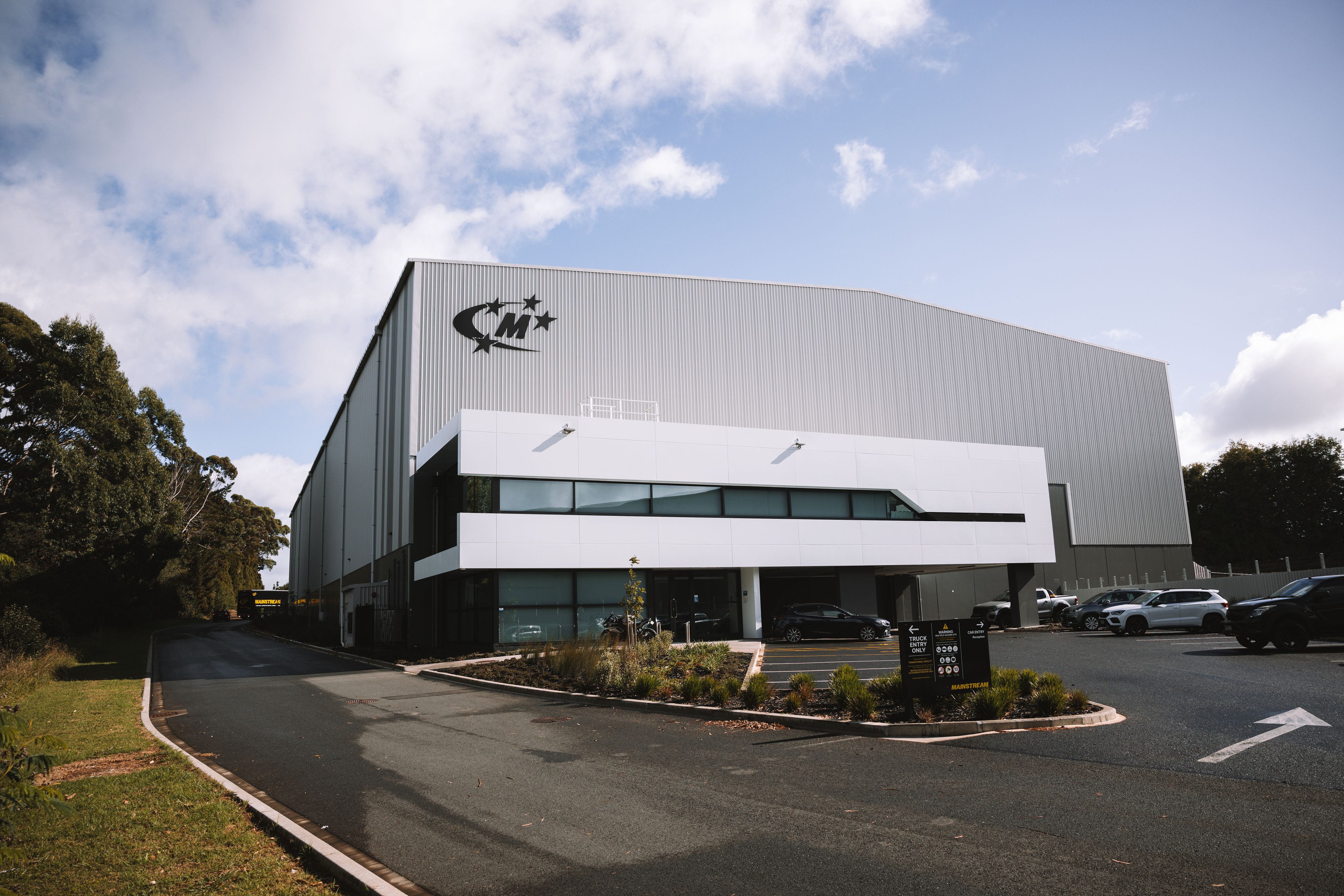 Distribution center surrounded by empty parking spaces and autumn trees