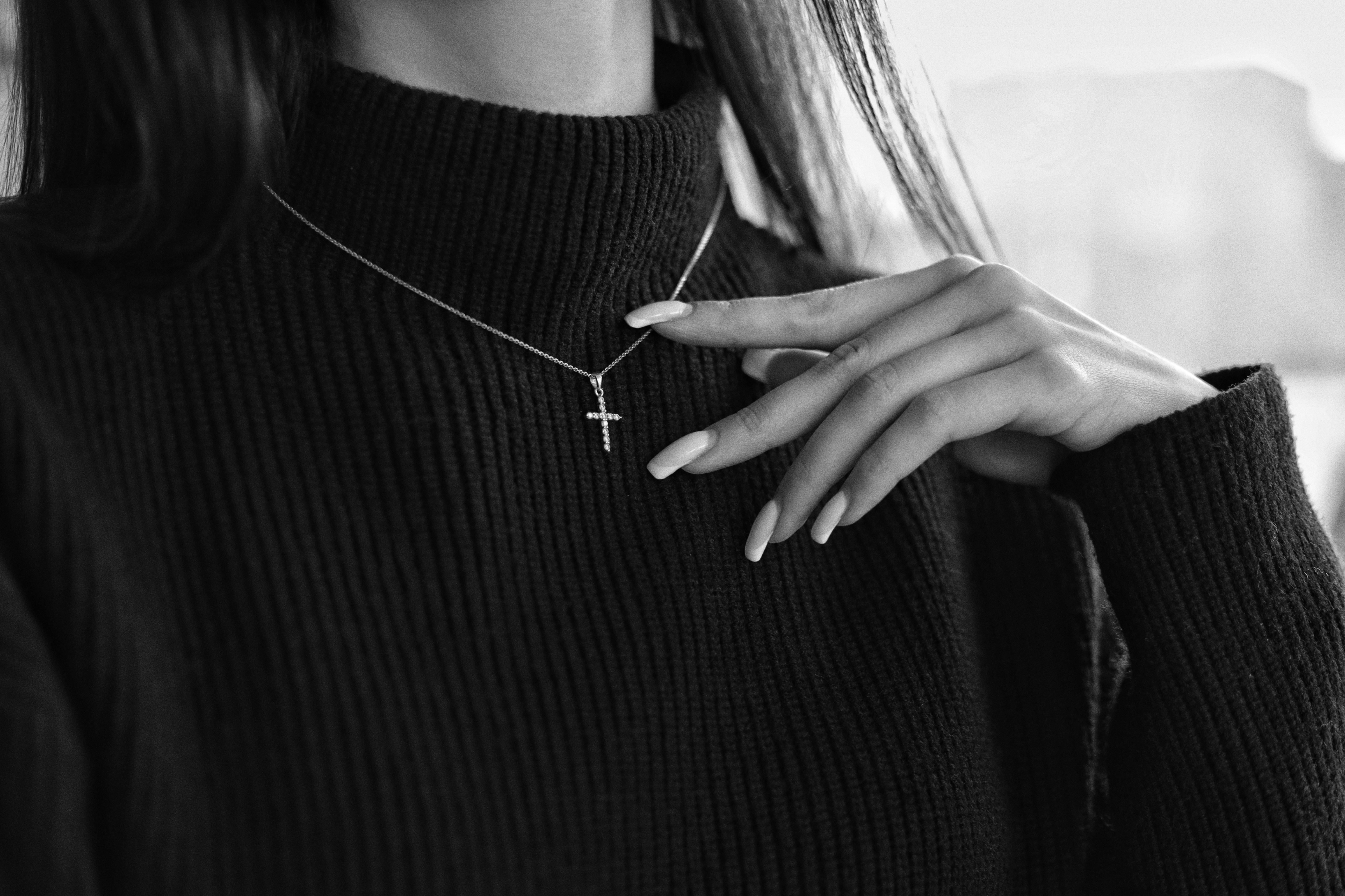 a woman wearing a necklace with a cross on it