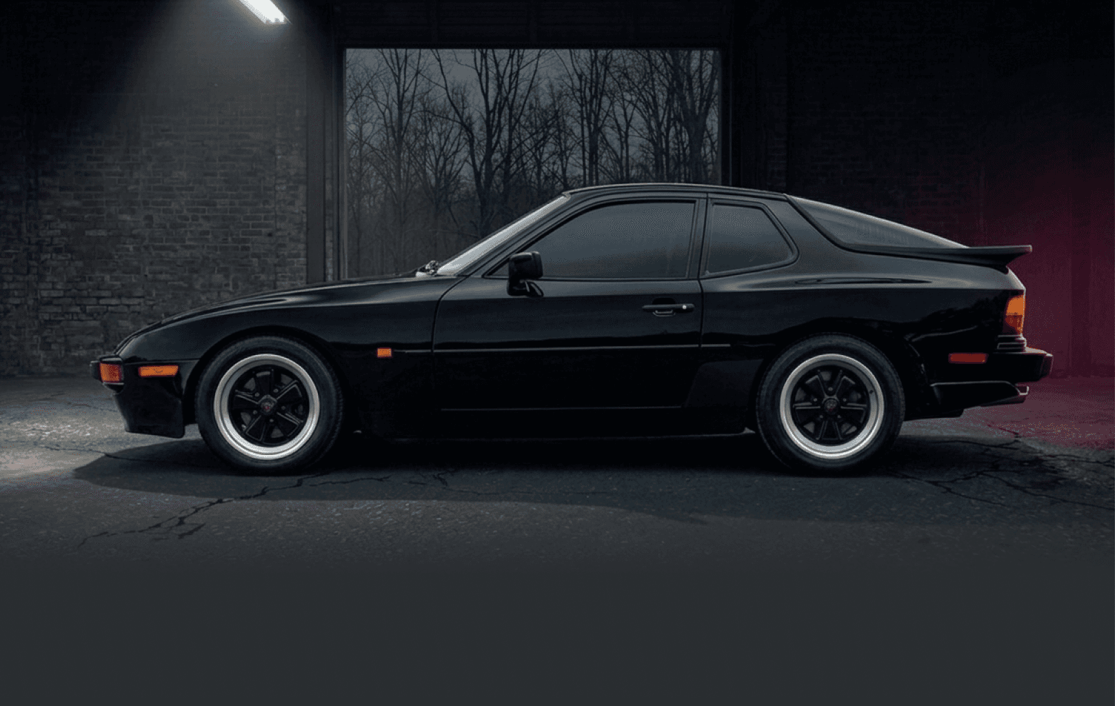 1985 Porsche 944 sitting in a parking lot at night.