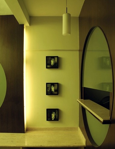 Nature-inspired preschool entrance with sculptural tree partitions and suspended green leaf ceiling panels.