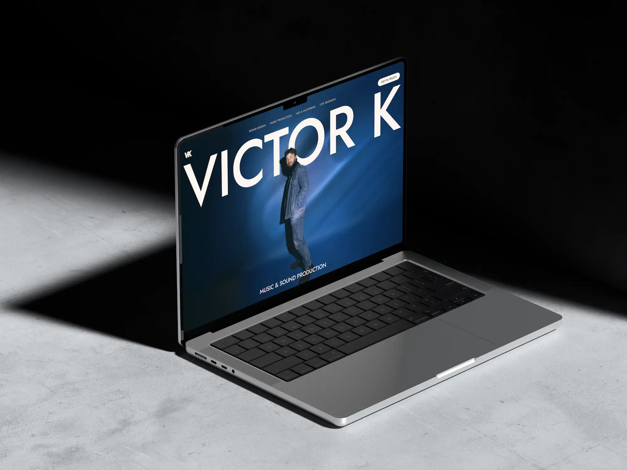 Macbook in dark environment with Victor K frontpage on it