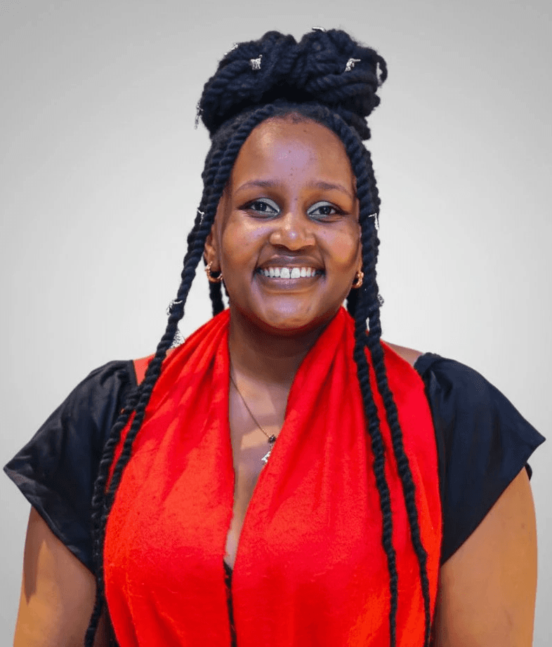 A smiling man in a suit and glasses sits at a table, with a modern office backdrop.