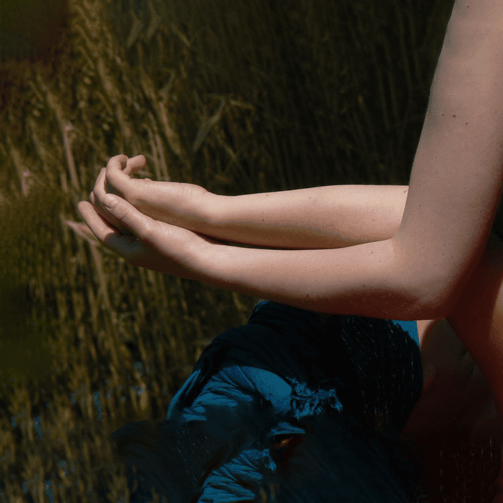 Silhouette assise en méditation, halo lumineux autour de la tête et sept chakras colorés alignés le long du corps.