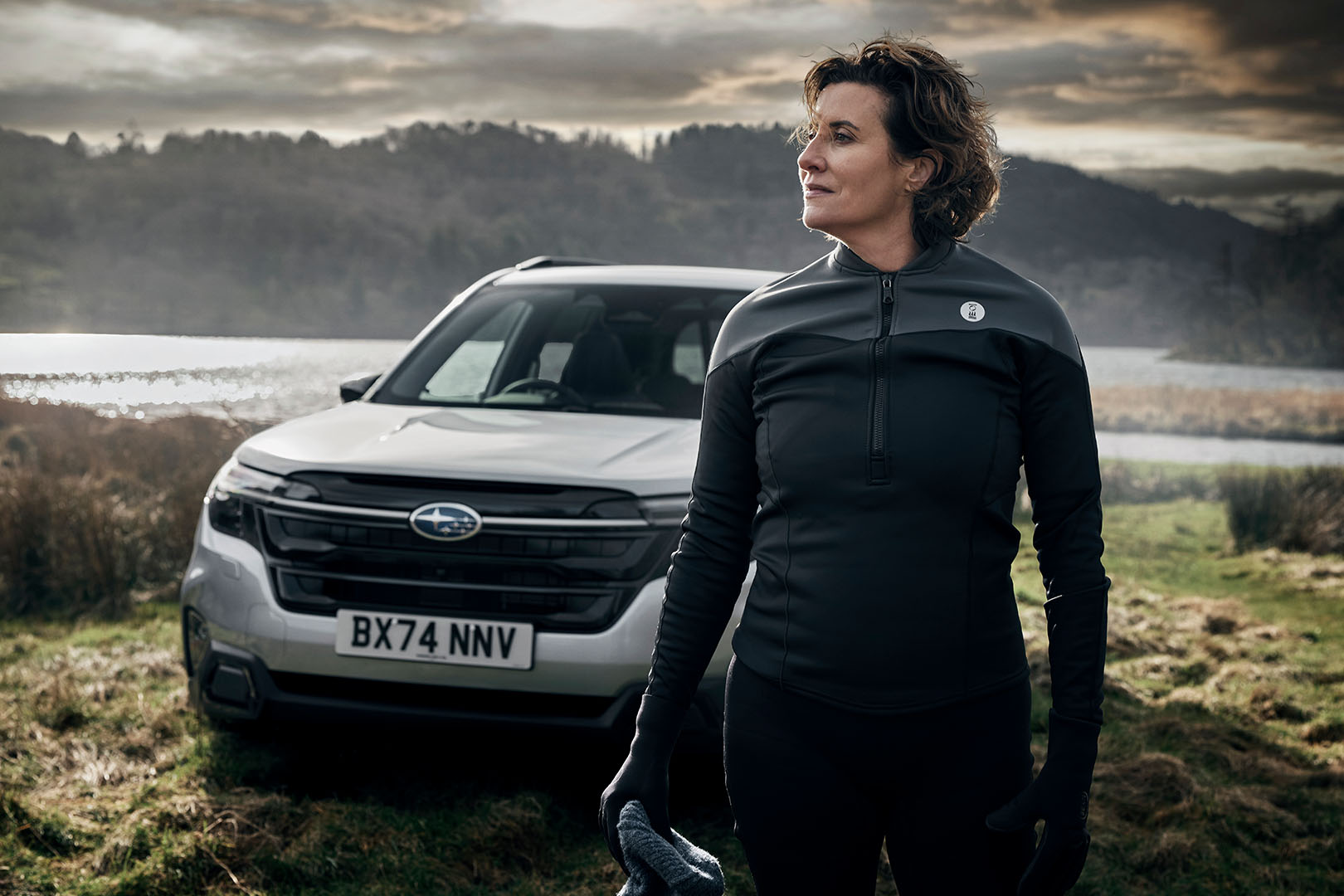 A woman with long brown hair wearing a striped blue shirt and beige apron, looking angry and screaming while holding a rolling pin in a kitchen.