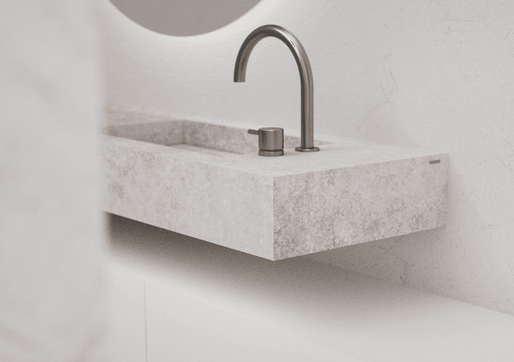 Modern glass and steel building with warm wooden ceilings, surrounded by lush greenery, blending contemporary architecture with nature.