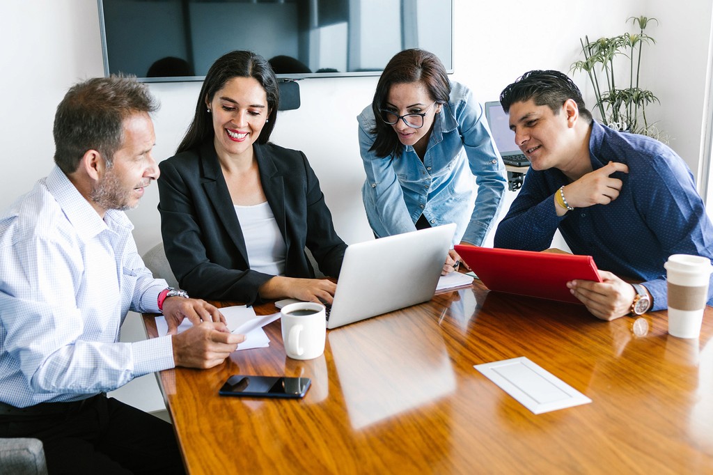 Líder de equipe mentorando e treinando funcionários reunidos em uma sala de reuniões