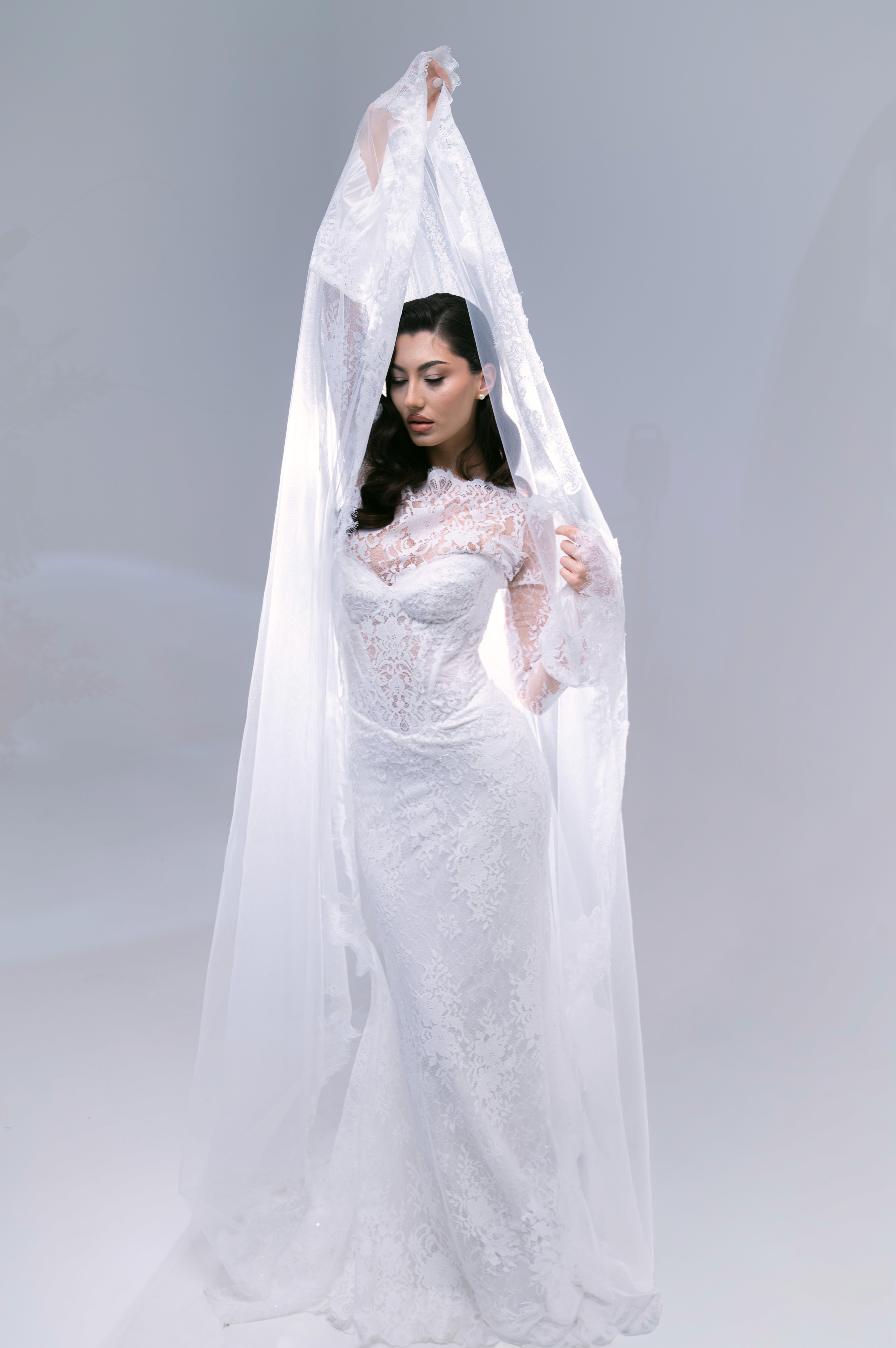 Mireasă fotografiată cu voal ridicat și lumină soft, ședință foto bridal în București