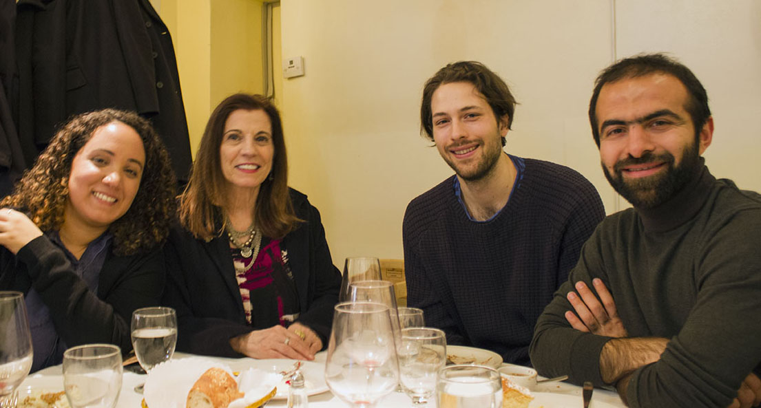 A photo of a group of people sitting at a table filled with glasses.