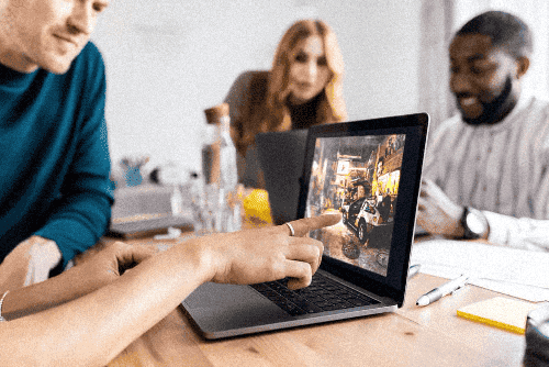 Des joueurs collaborent pour relever le défi interactif PopCorn Garage pendant un team building dans un bureau.