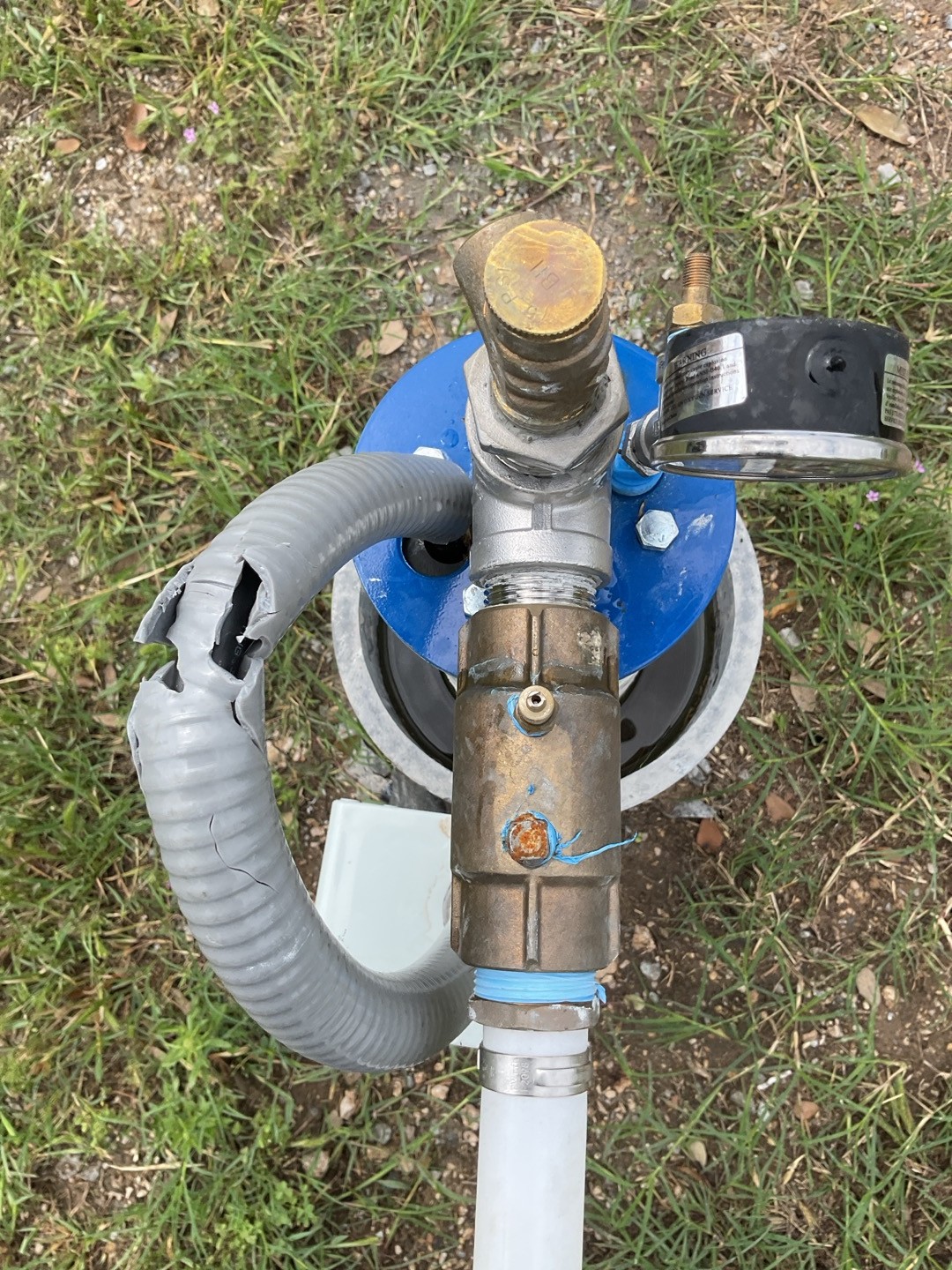 Hail-damaged wellhead with cracked cable on a North Texas rural property after a spring storm