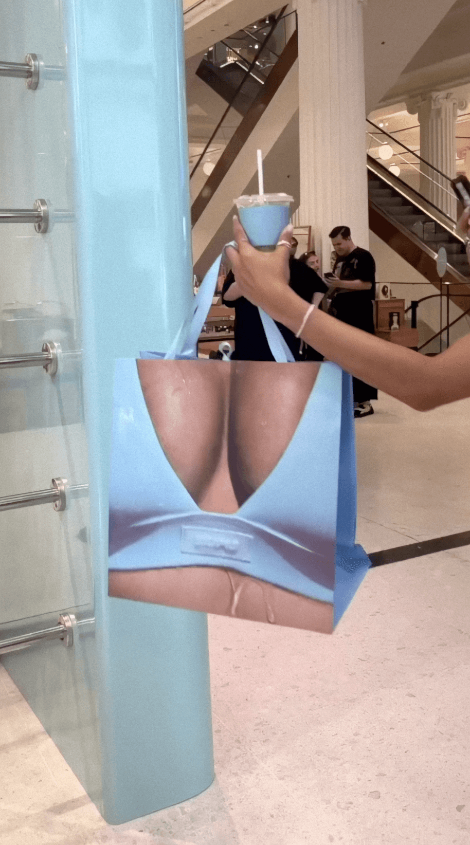 Bride sitting on ground against wall, groom standing nearby