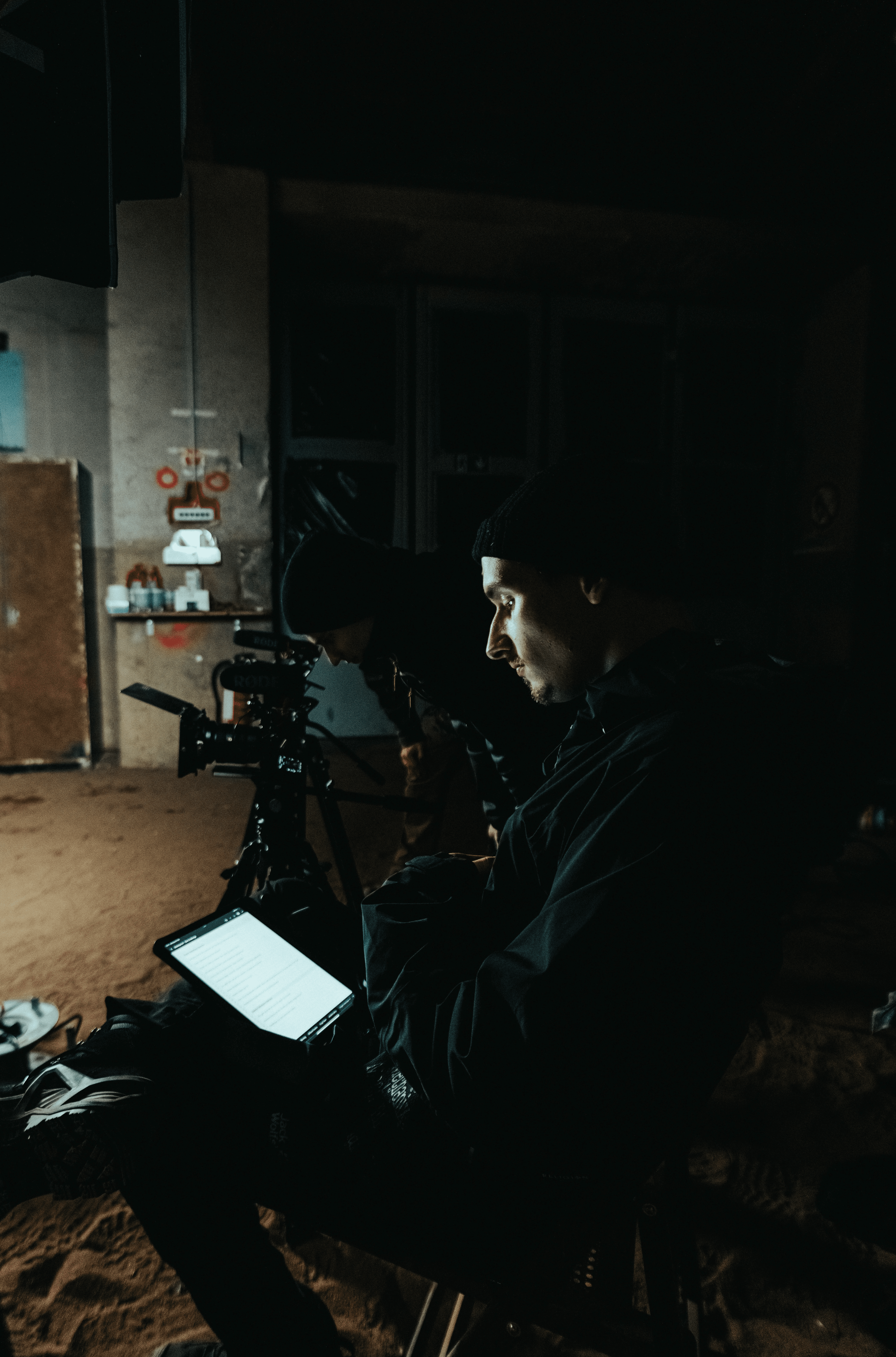 A close-up of a pink cocktail in a martini glass, set against a nighttime background with soft, blurred colors.